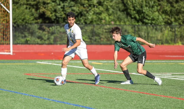 Two men playing soccer at Elliot Field