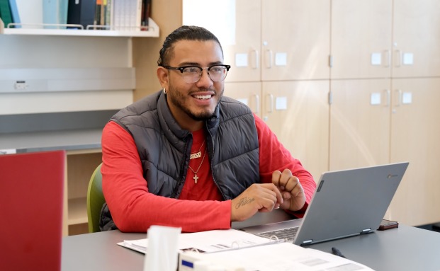 Male student on laptop in classroom