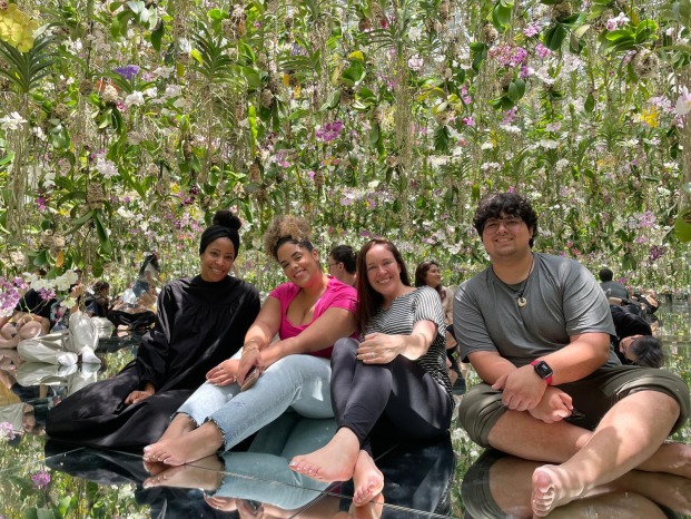 students and staff in Japan sitting amongst flowers