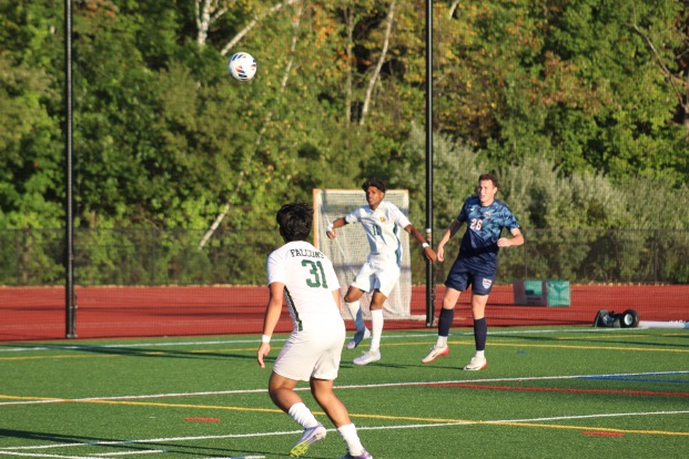 Two falcon soccer players and opposing team with ball midair.