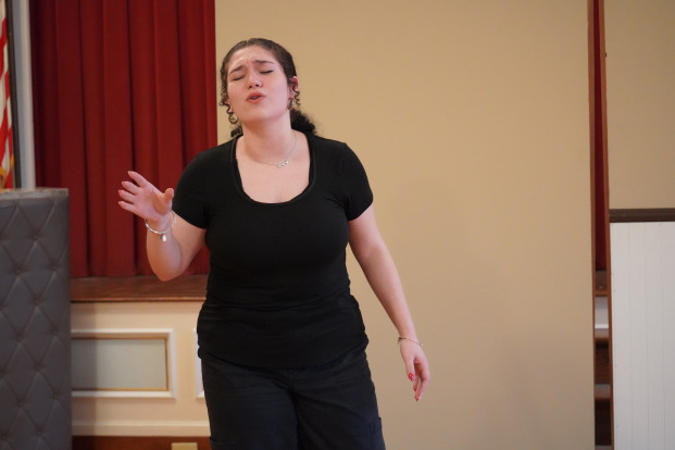 Jaylis singing with eyes closed in theater production.