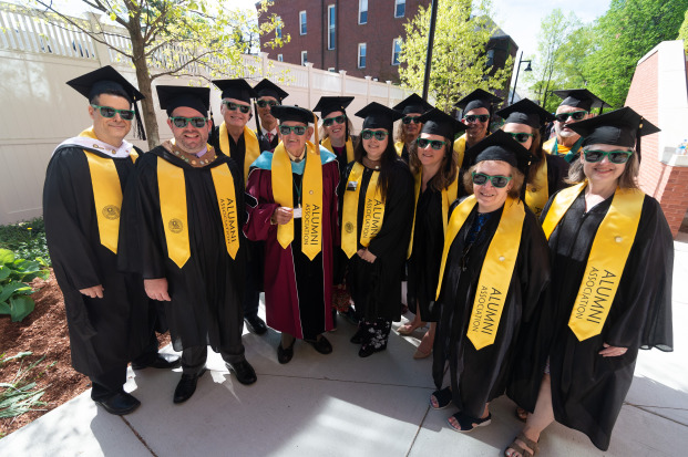 Alumni wearing, caps, gowns, Alumni Association stoles and sunglasses at Commencement