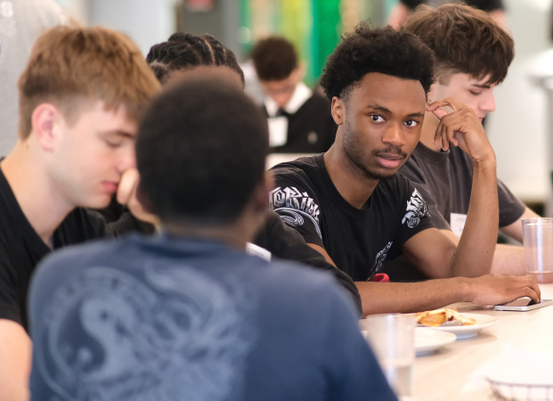 Male students talking at a table in Holmes.