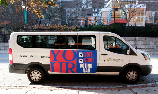 Fitchburg State van with Your Vote, Voice, Voting Van sign on it in front of Russell..