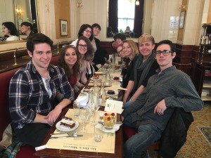 Students posing at table eating dinner in Paris on study abroad trip