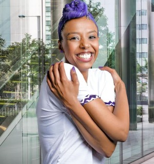 Embrace Equity female in purple giving herself a hug