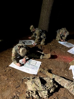 ROTC recruits in woods at night doing land navigation