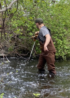 Student in stream measuring stream width