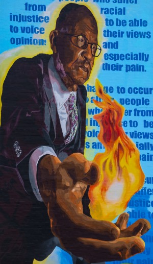 Adrian Ford Mural him holding flame with writing behind him