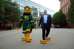 Freddy walks with the creator of the falcon mascot, alum Jason Polonsky