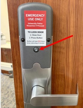 Door handle with panic button highlighted with arrow.