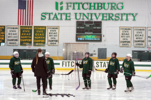 Club ice hockey team listens to instructions from Olympian Gigi Marvin