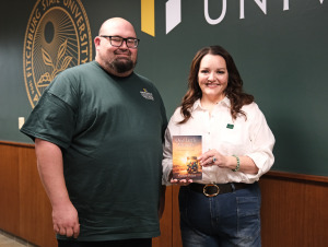 Nathan Fisher with his book along with President Donna Hodge