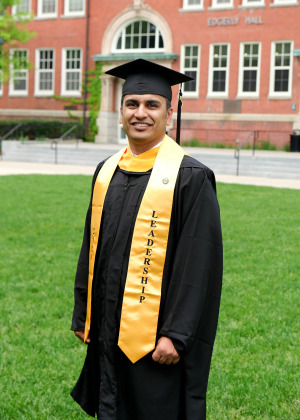 Ali Raza standing on quad in cap and gown