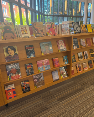 Wooden bookstore display filled with colorful books about Latino and Hispanic culture, history, literature, and identity in a bright room with large windows.