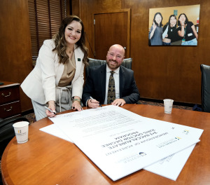 President Hodge with Suffolk's Anthony Orlando signing law agreement