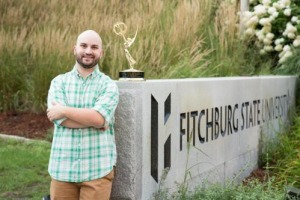 Danny Quin next to the Fitchburg State sign