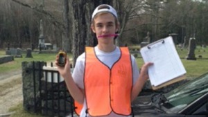 Tyler Godin wearing a neon vest and holding a GIS and a clipboard