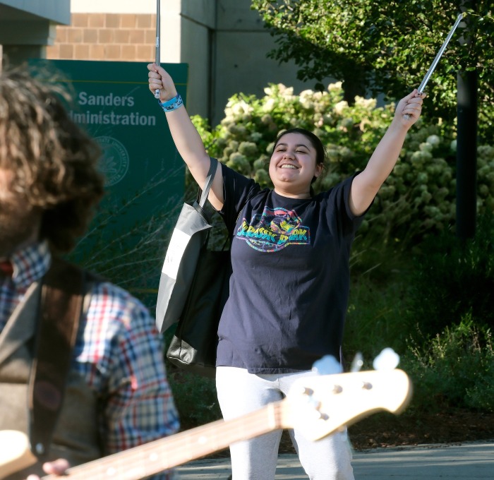 Female student dancing and conducting the band playing at rock the block